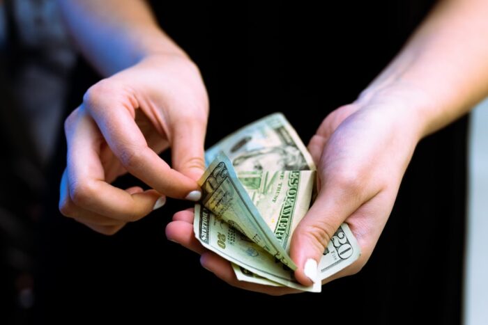 Photo by Igal Ness person holding fan of 100 us dollar bill