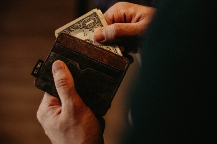 Photo by Allef Vinicius person getting 1 U.S. dollar banknote in wallet